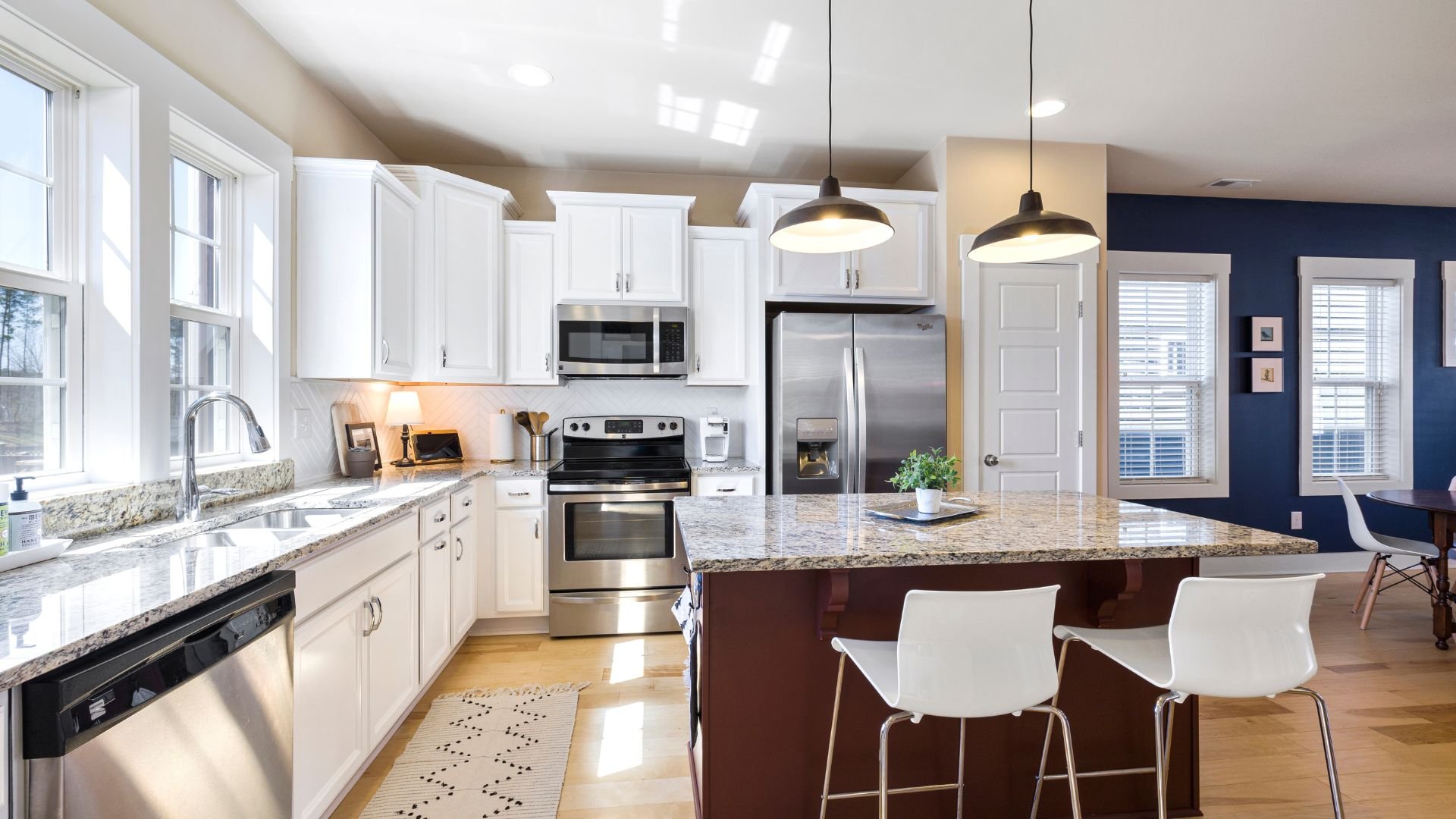Modern kitchen with white cabinets, granite counters, and pendant lights
