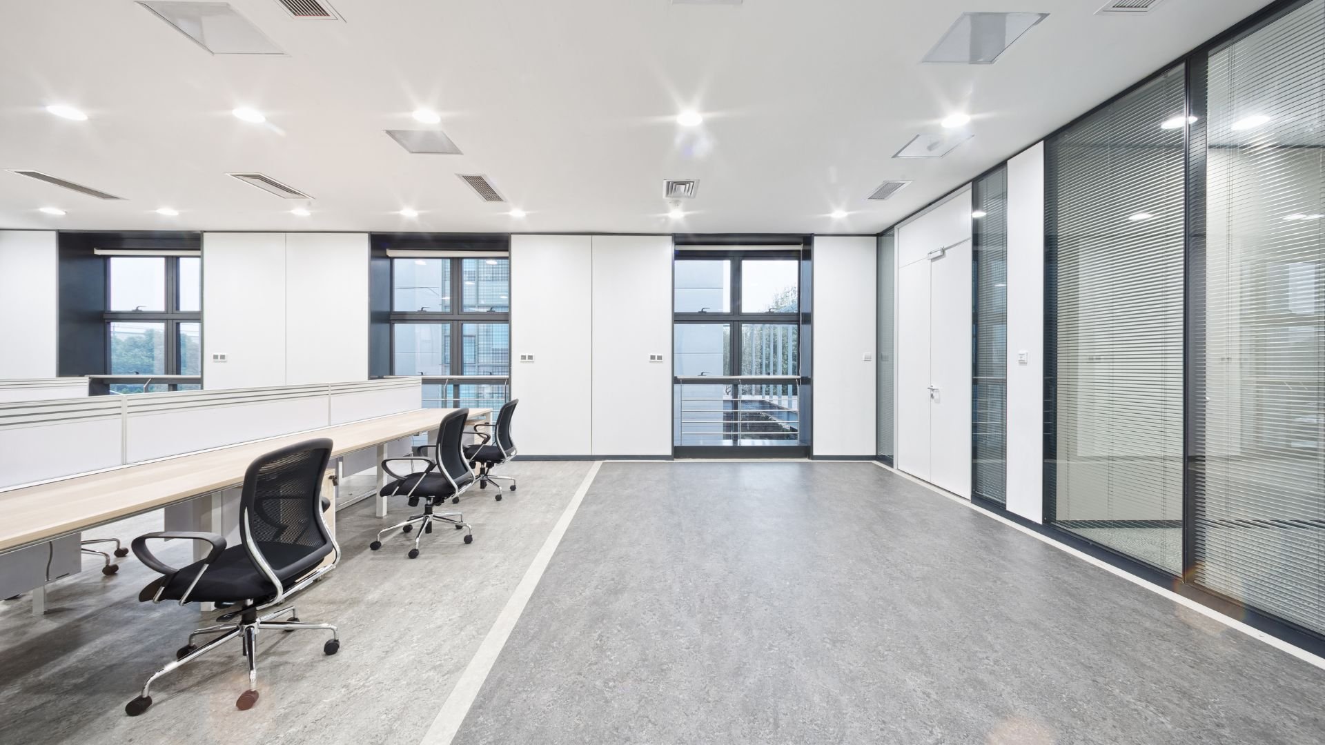 Modern, empty office space with large windows and ergonomic chairs